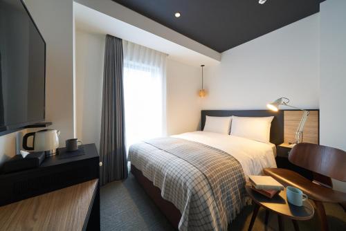 a hotel room with a bed and a television at Hotel Resol Ueno in Tokyo