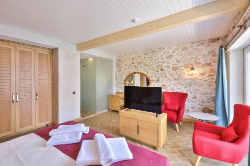 a living room with a tv and two red chairs at Atalante Hotel in Kas
