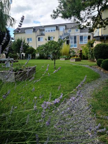 a garden with purple flowers in front of a building at Landhotel Saar-Mosel in Tünsdorf