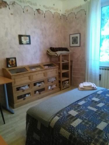 a bedroom with a bed and a wooden dresser at Pegli The Artist's House, Seaside And Sun in Genoa