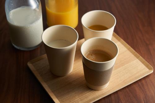 four cups of coffee sitting on a wooden tray at Hotel Resol Ueno in Tokyo