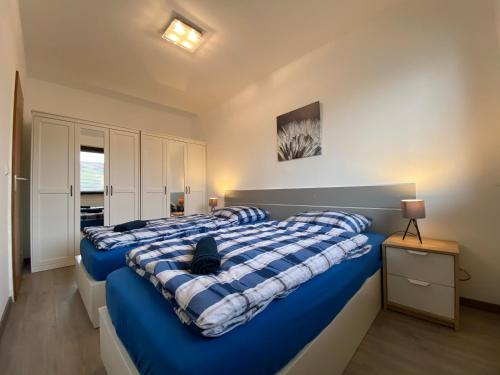 2 Betten in einem Schlafzimmer mit blauer und weißer Bettwäsche in der Unterkunft Apartment in Uninähe in Lübeck