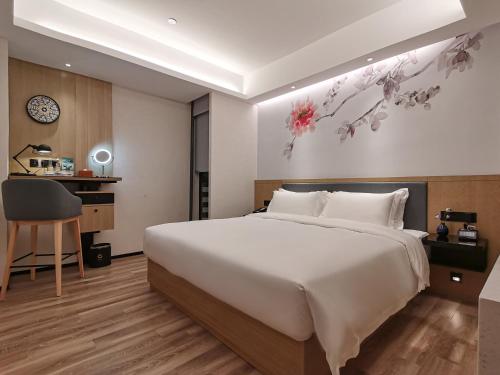 a bedroom with a large bed and a desk at Paco Hotel BeiJing Road Metro Guangzhou-Free Shuttle Bus For Canton Fair in Guangzhou
