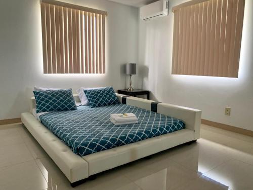 a bedroom with a bed with a blue comforter at Private Chalan Pago Apartment in Hagatna