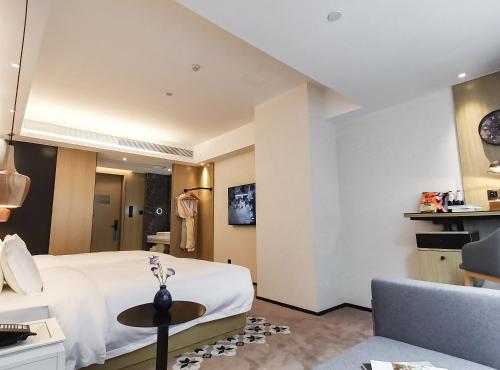 a hotel room with a bed and a chair at Paco Hotel BeiJing Road Metro Guangzhou-Free Shuttle Bus For Canton Fair in Guangzhou