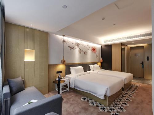 广州Paco Hotel BeiJing Road Metro Guangzhou-Free Shuttle Bus For Canton Fair的配有一张大床和一张沙发的酒店房间