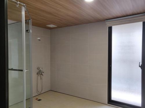 uma casa de banho com um chuveiro e uma porta de vidro em 星之芳庭 潮州民宿 親子寵物友善 em Chaozhou