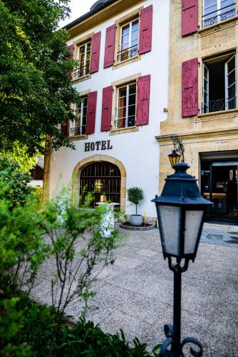 a street light in front of a building with red shutters at Hôtel Restaurant Bellevue in Onnens