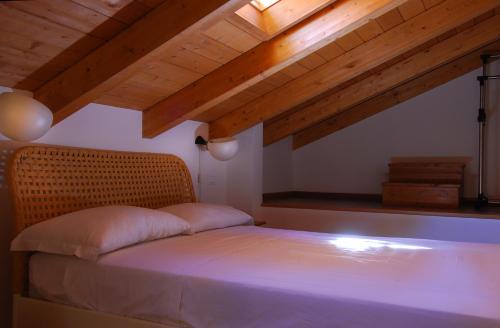 a bed in a room with wooden ceilings at GetTheKey Boldrini Lofts in Bologna