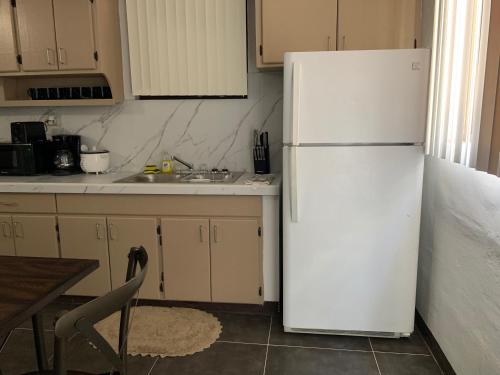 a kitchen with a white refrigerator and a sink at BEAUTIFUL 3 BEDROOM PRIVATE UNIT, FREE PARKING, FREE WIFI in Sinajana