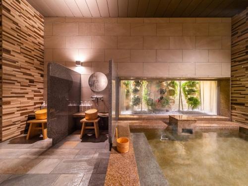 a bathroom with a pool of water in a room at Super Hotel Beppu Ekimae in Beppu