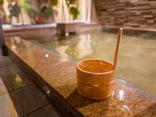 a wooden cup with a spoon sitting on a counter at Super Hotel Beppu Ekimae in Beppu
