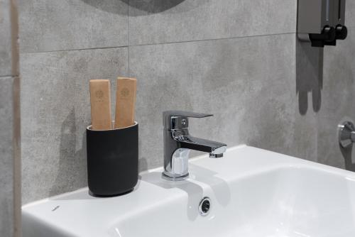 um lavatório de casa de banho com uma torneira e dois paus de madeira em Mina Hotel Arbat em Vladivostok