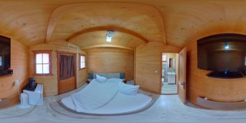a large room with a bed and a flat screen tv at Casutele Deny Băile Figa cu aer condiționat in Beclean