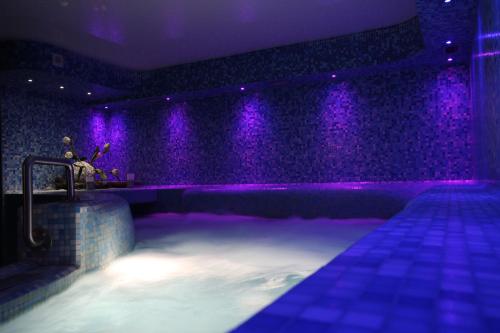 une chambre avec des lumières violettes sur une scène dans l'établissement Maritan Hotel & Spa, à Padoue