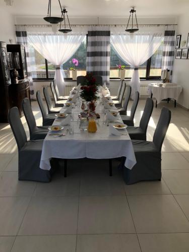 a dining room with a long table and chairs at Zajazd Maj in Bolesław