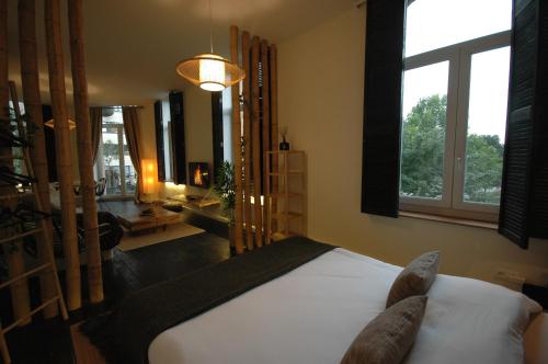 a bedroom with a bed and a large window at SLEEP INN - Japanese Loft with balconyview citycenter in Antwerp