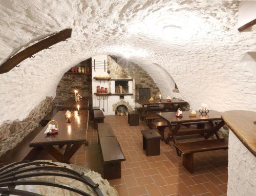 un restaurante con mesas de madera y una pared de piedra en Penzion Na 15. Poledníku, en Jindřichův Hradec