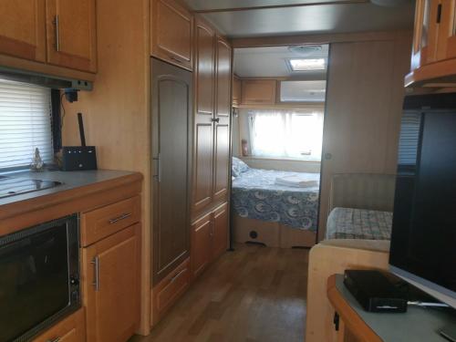 a room with a kitchen and a bedroom in an rv at Sea Caravan/Camper on the Beach in Kiten