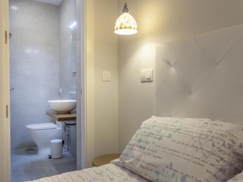 łazienka z łóżkiem, umywalką i toaletą w obiekcie RD APARCAMIENTO INCLUIDO TRIANA luminoso cómodo apartamento 2Bd 2Bth w Sewilli