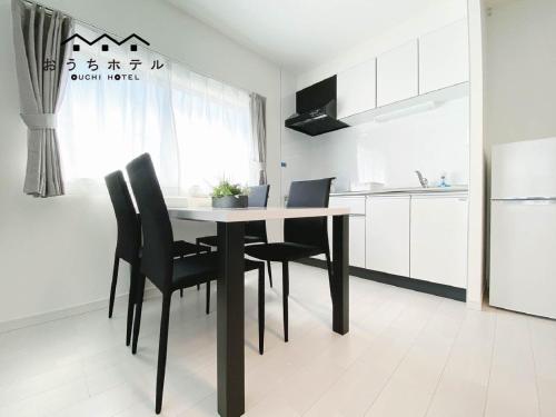 a dining room table with black chairs in a kitchen at OUCHI HOTEL Miyajimaguchi in Hatsukaichi