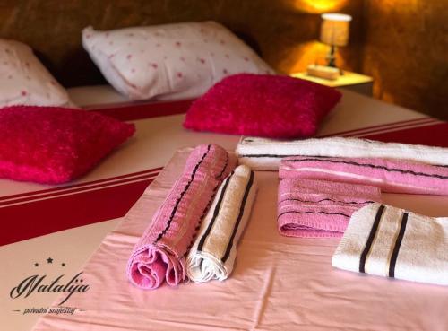 a bed with pink and white towels and pillows at Smještaj Natalija in Osijek