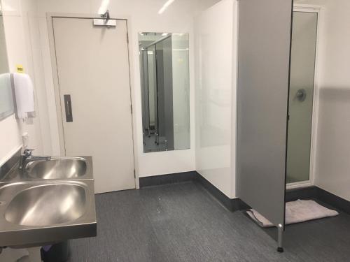 a bathroom with a sink and a mirror at Surf 'N' Snow Backpackers Across Sky Tower in Auckland