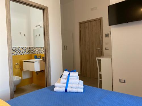 a hotel room with a pile of towels on a bed at L’Angolo Chiaro in Taviano