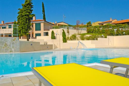 a swimming pool with a yellow table in front of a building at Residence Villa Beuca in Cogoleto