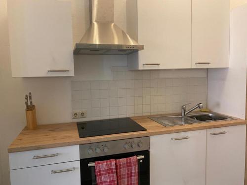 a kitchen with white cabinets and a stove top oven at Ferienappartment zum grünen Hirsch in Bad Ischl