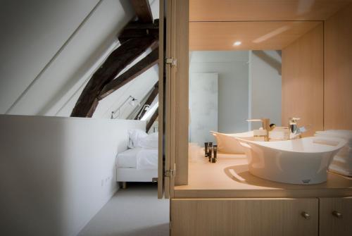 a bathroom with a bath tub and a bedroom at Teaching Hotel in Maastricht