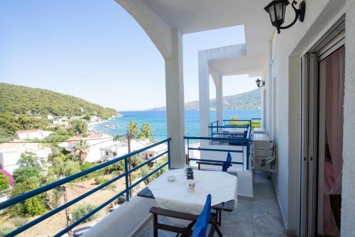 a dining room with a balcony overlooking the ocean at Christine Studios in Poros