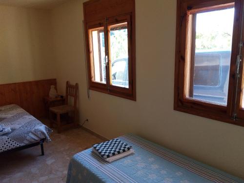 um quarto com uma cama e duas janelas em villa Garibaldi em Agüero