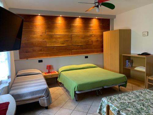 a bedroom with two beds and a flat screen tv at Agriturismo Gli Ulivi in Garlenda