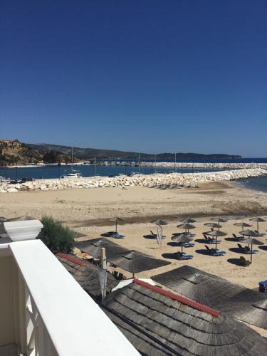 a view of a beach with lounge chairs and the ocean at Hotel Samaras Beach in Limenaria