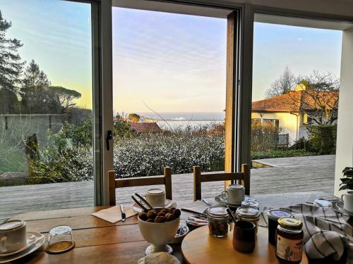 a dining table with a view of the ocean at Les Digues Vauban in Ciboure