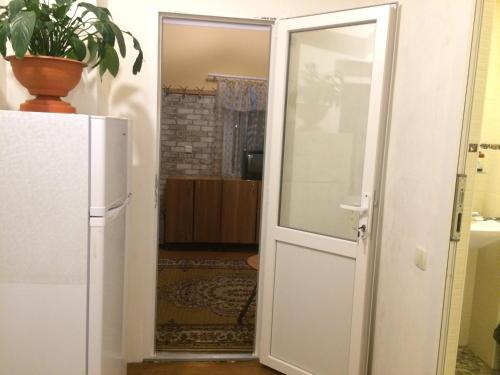 eine Tür, die in ein Zimmer mit einem Kühlschrank führt in der Unterkunft Сдам комнату в гостевом домике in Odessa