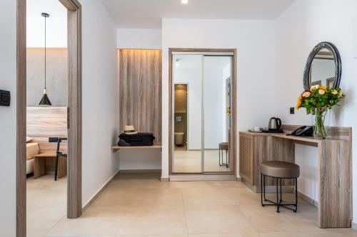 a room with a mirror and a vanity and a room with a bed at ONEIRO Boutique Hotel in Tigaki