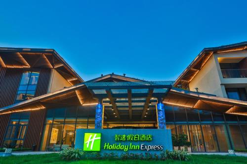 a building with a sign in front of it at Holiday Inn Express Emei Mountain by IHG in Emeishan