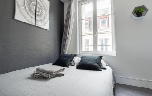 une chambre avec un lit avec des oreillers et une fenêtre dans l'établissement Studio Le Cosy - 100m Plage d'Etretat - 4 personnes, à Étretat