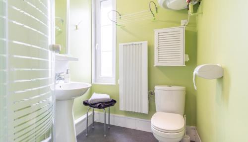 La salle de bains est pourvue de murs verts, de toilettes et d'un lavabo. dans l'établissement Studio Le Cosy - 100m Plage d'Etretat - 4 personnes, à Étretat