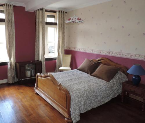 sypialnia z łóżkiem i różową ścianą w obiekcie Gîte du Nouvion w mieście Le Nouvion-en-Thiérache