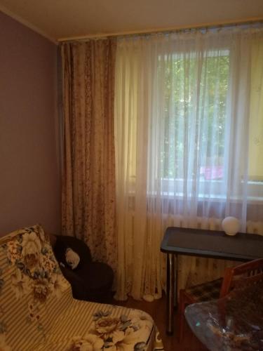 - une chambre avec un lit et une fenêtre avec des rideaux dans l'établissement Flat Trocka Street, à Varsovie
