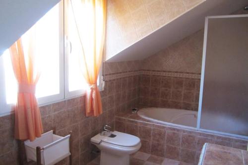 a bathroom with a toilet and a bath tub at Casa rural a 20 minutos de la Alhambra in Granada