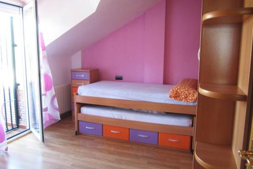 een slaapkamer met een bed en een roze muur bij Casa rural a 20 minutos de la Alhambra in Granada