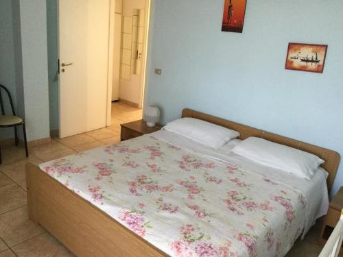 ein Schlafzimmer mit einem Bett mit einer Blumendecke darauf in der Unterkunft Casa Rosa in Porto SantʼElpidio