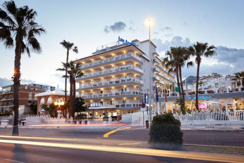 un hotel con palmeras frente a un edificio en Hotel Las Arenas, Affiliated by Melia, en Benalmádena