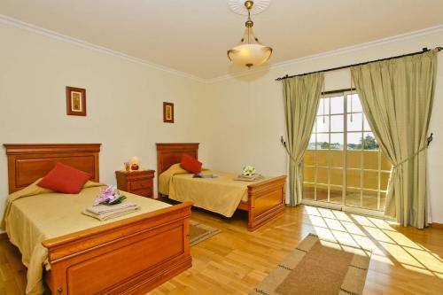 a bedroom with two beds and a large window at Villa João Paulo in Albufeira