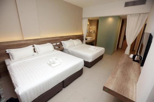 a hotel room with two beds and a television at D&F BOUTIQUE HOTEL SEREMBAN 2 in Seremban