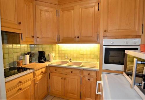 La cuisine est équipée de placards en bois, d'un évier et d'un four micro-ondes. dans l'établissement Résidence du Mont-Blanc n°5Bis, à Combloux